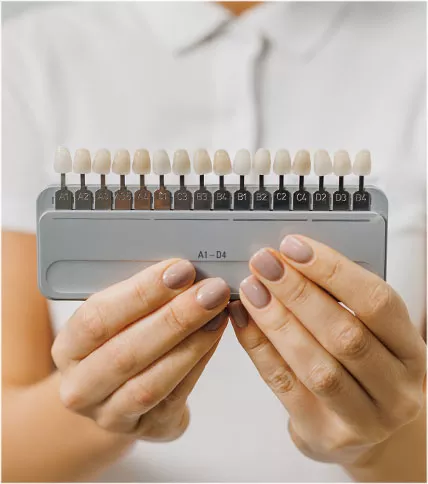 Person holding a whitening shade guide.